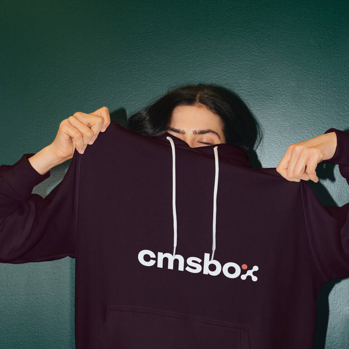 Person mit einem dunklen Hoodie mit prominentem cmsbox-Logo.