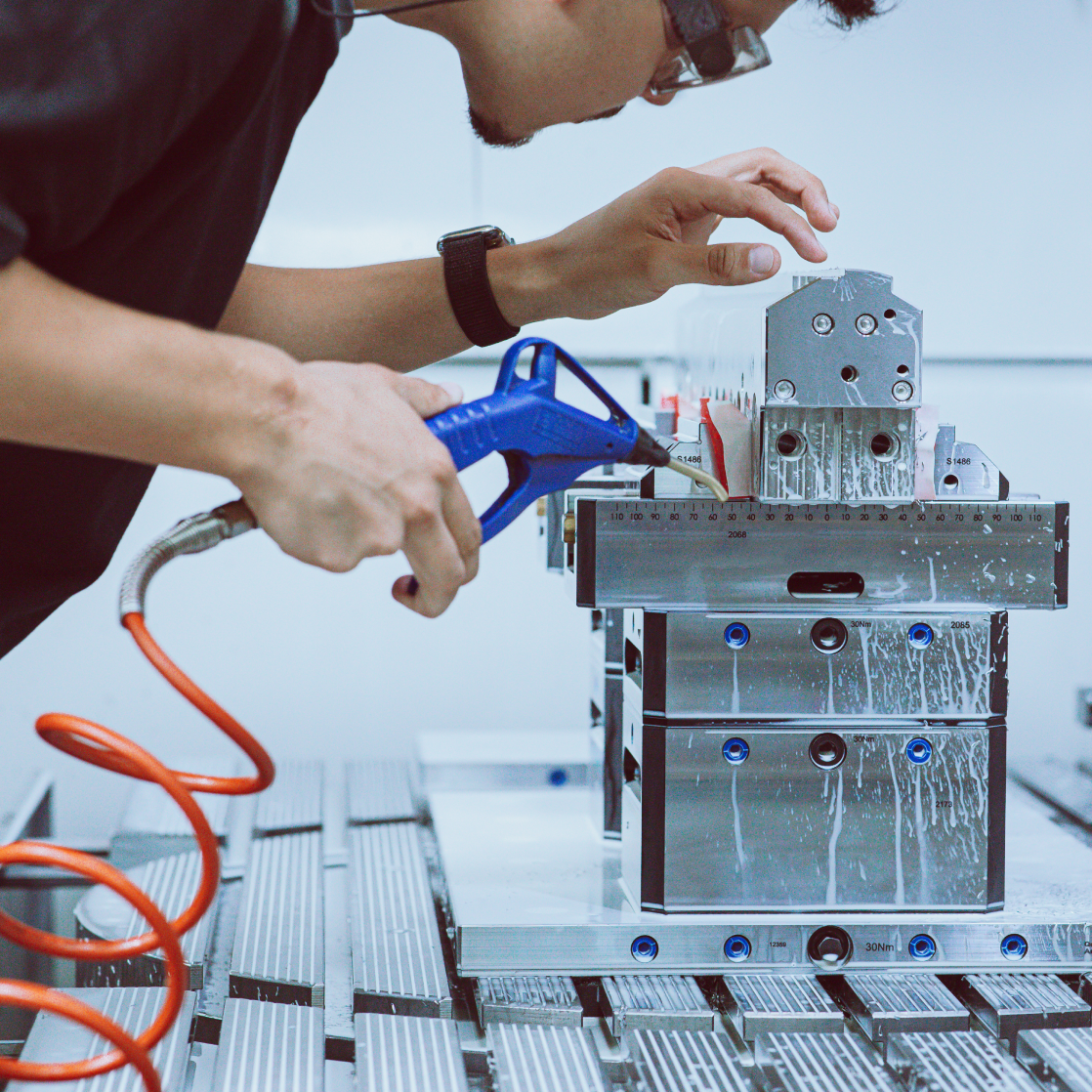 Mitarbeiter Mitarbeitender bei der Arbeit an einer präzisen Düse mit Luftdruckgerät.