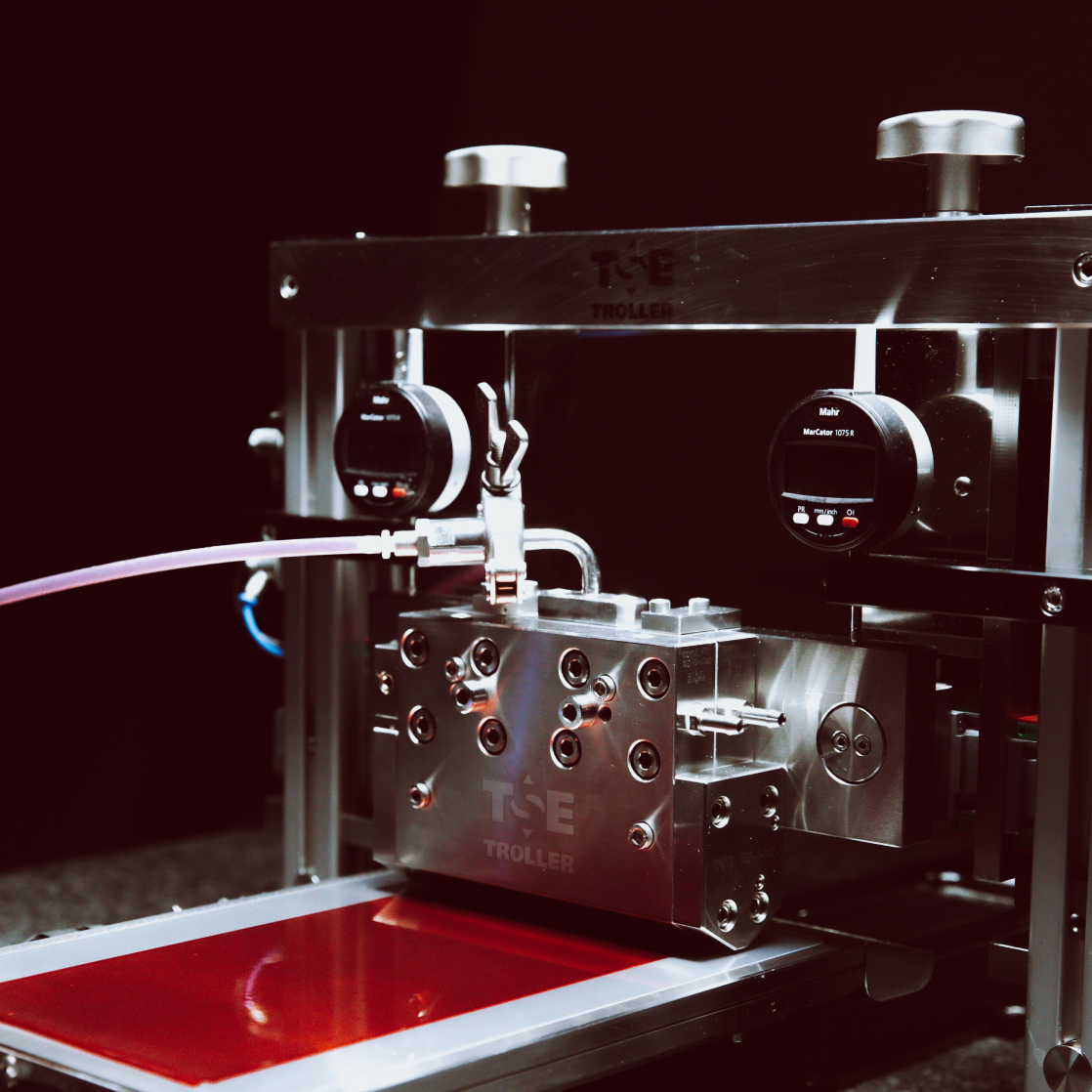 Maschine für die Beschichtung Maschine von TSE Troller beim Beschichtungsprozess mit rotem Trägerband.